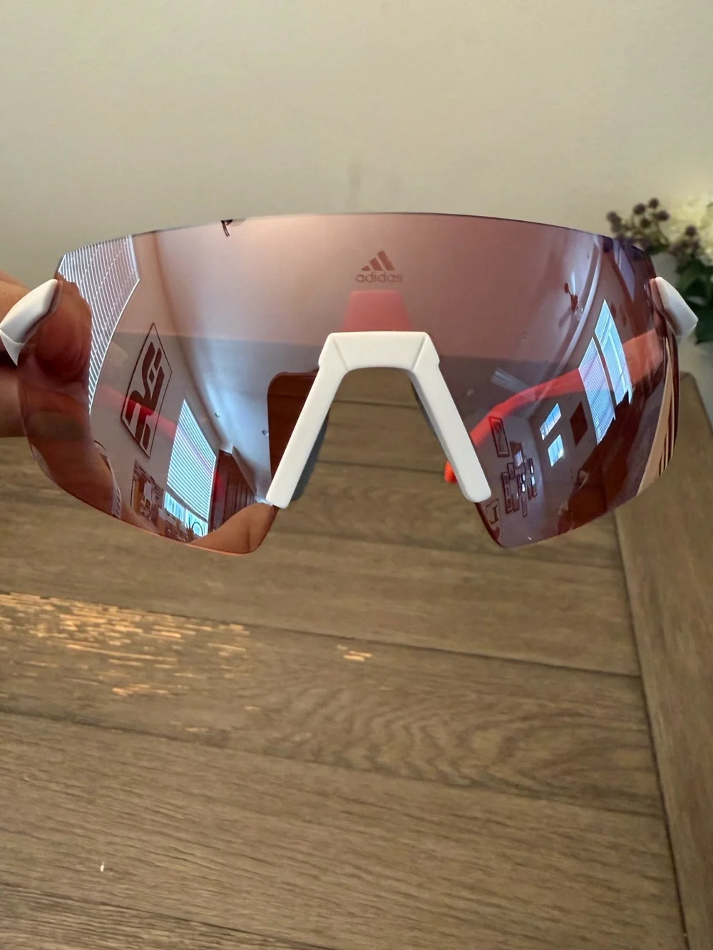 Adidas Sport SP0077 rimless shield sunglasses feature a white/red frames.